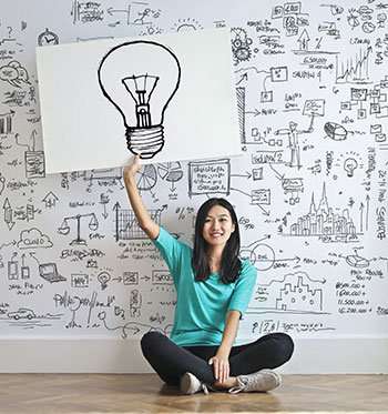 Woman Draw a Light bulb in White Board